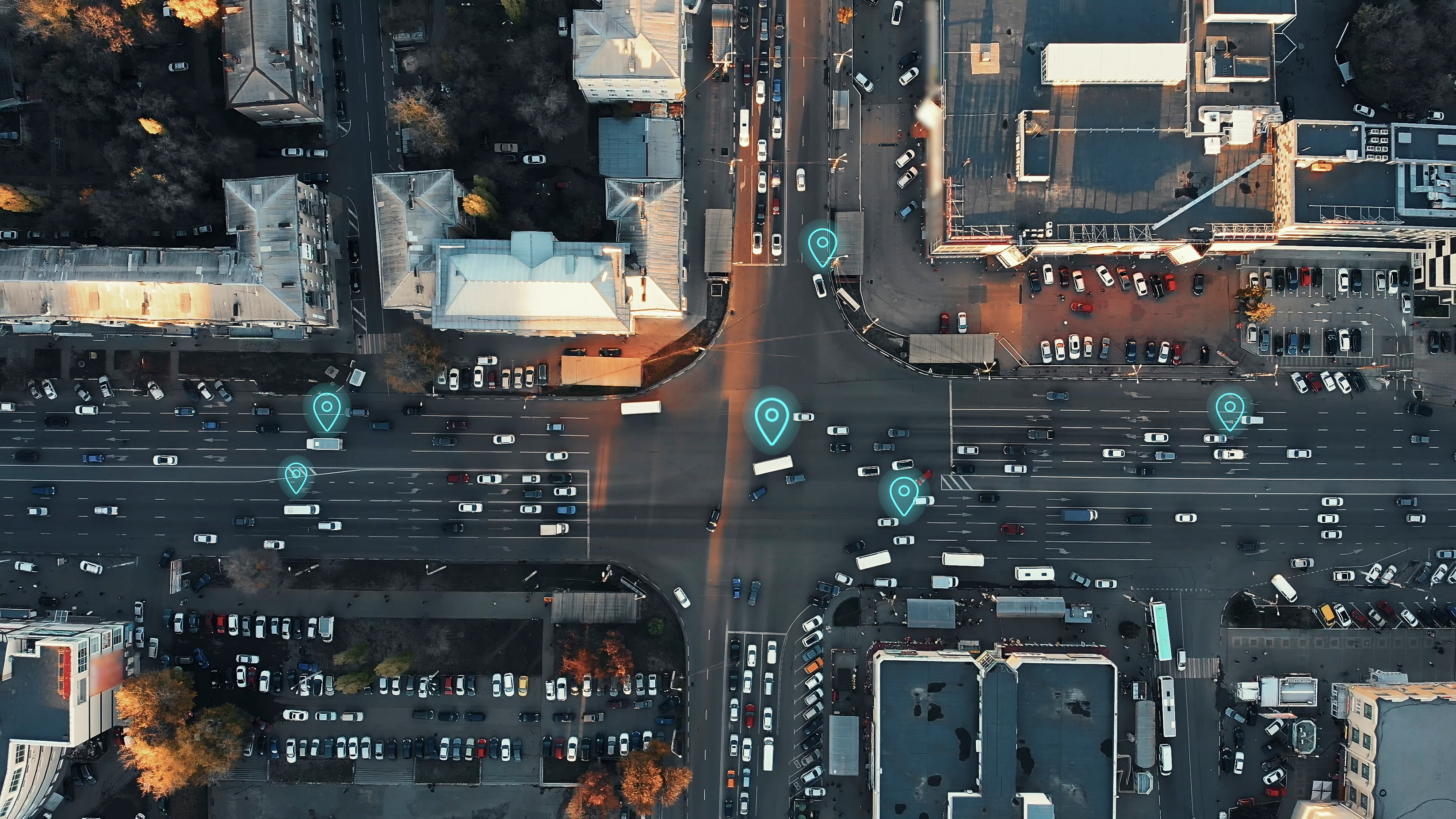 Aerial view of a busy city intersection with digital location markers above vehicles.